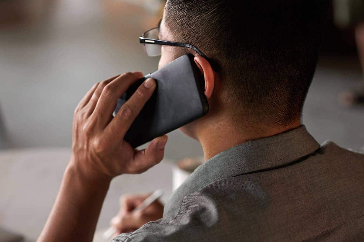 Closeup of man on smartphone listening to hold music